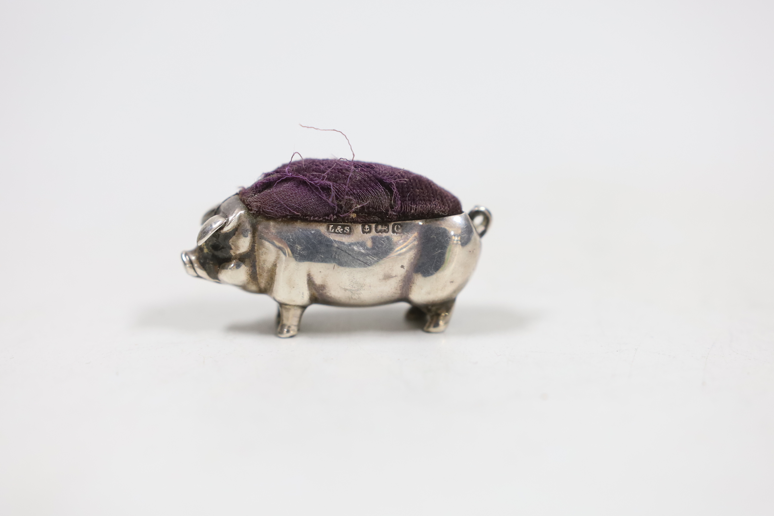 An Edwardian novelty silver pin cushion, modelled as a pig, Levy & Salaman, Birmingham, 1902, length 48mm.